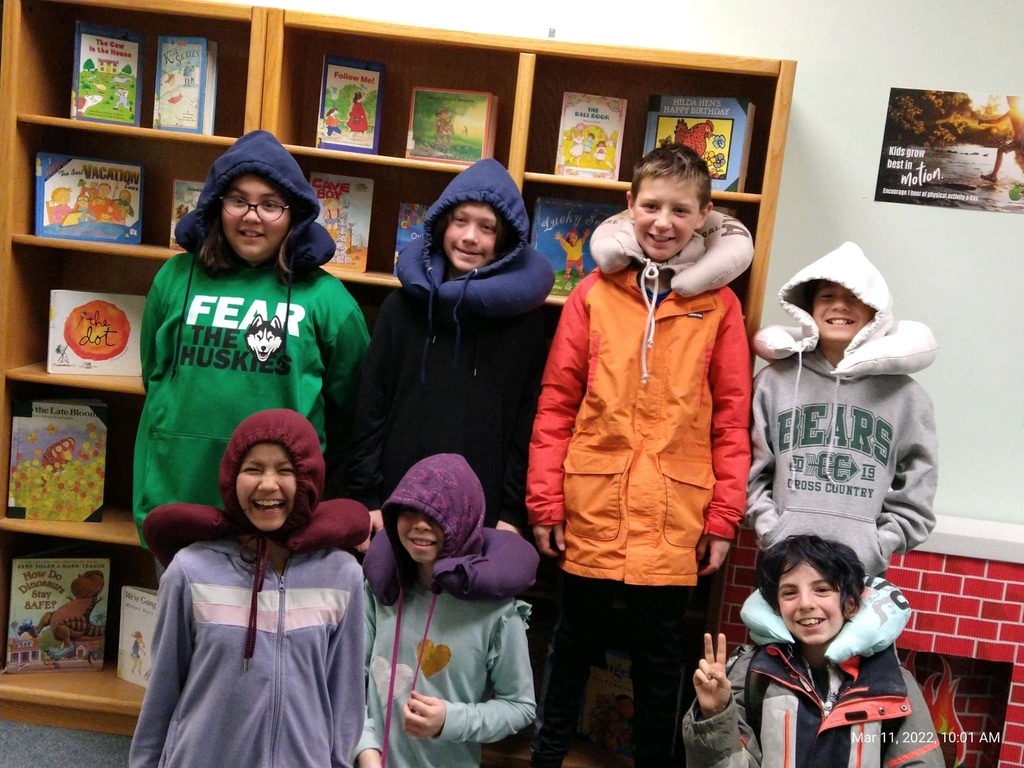 students wearing neck pillows made from old hoodies in from of a book case